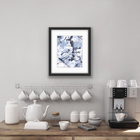 An abstract acrylic painting on paper in a black frame. The colours are a soft grey/blue, bllack and white The painting hangs in a kitchen above a coffee station.